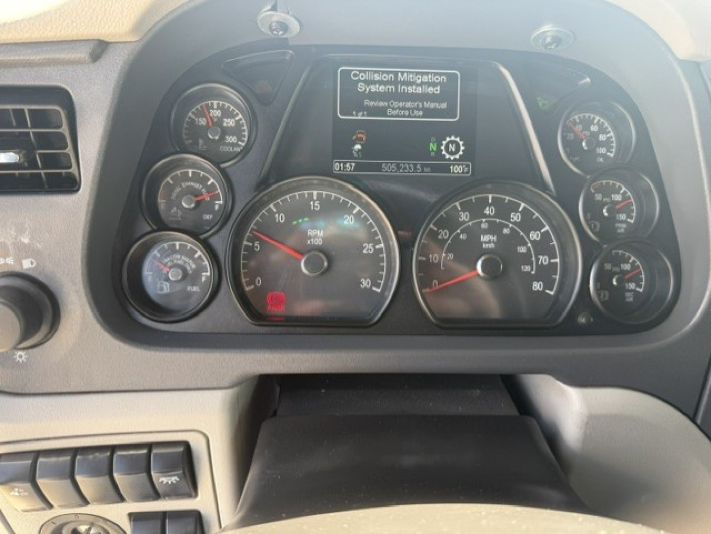 Peterbilt 579 instrument cluster and dashboard displaying gauges and a central monitor.