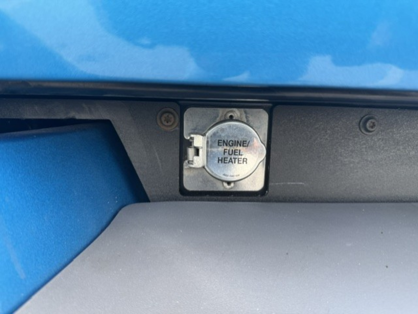 Peterbilt 579 engine bay showing engine fuel heater cover with cap labeled ENGINE FUEL HEATER.
