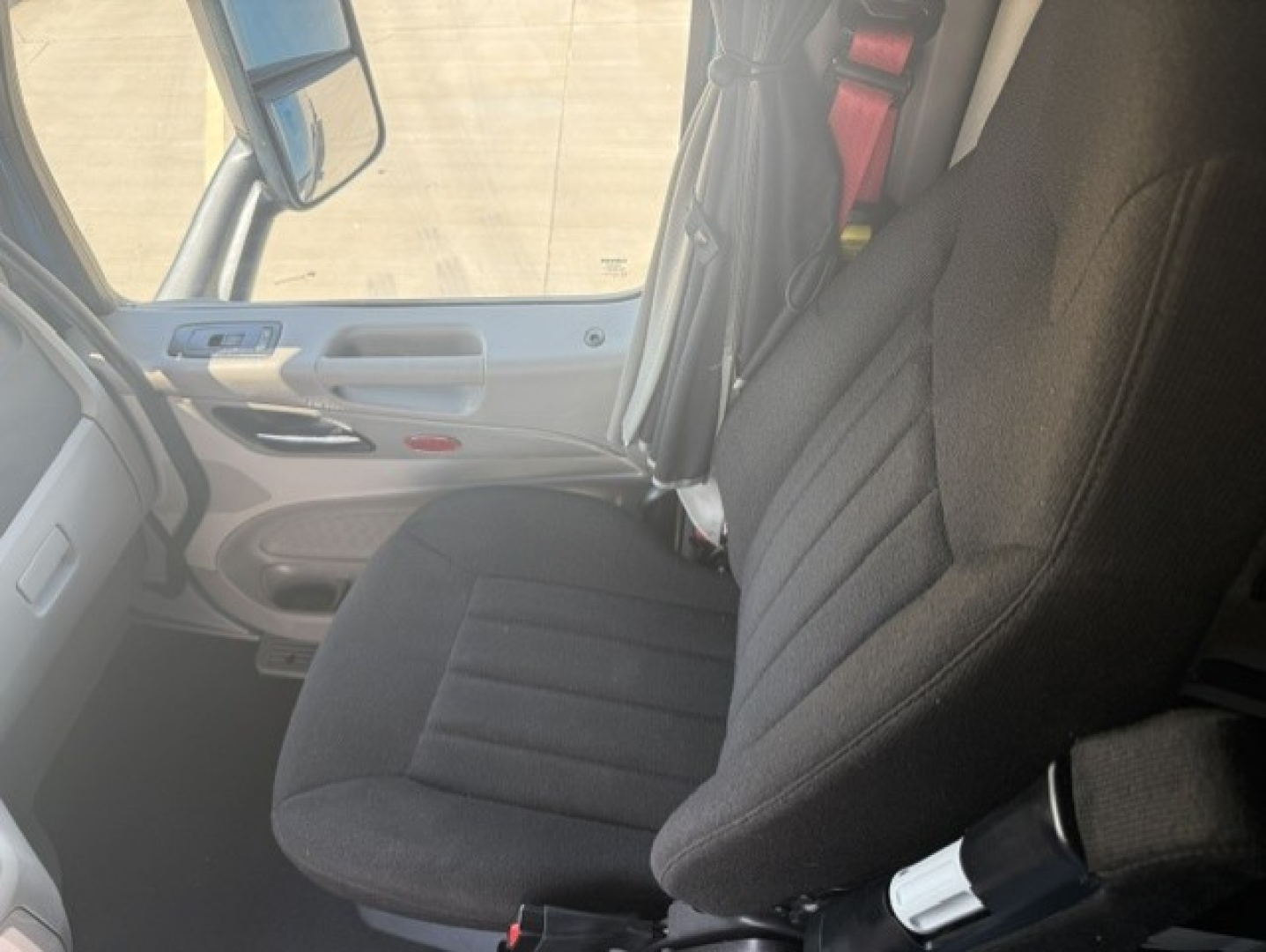 Peterbilt 579 interior front seat view with driver seat and door panel visible.