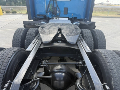 Peterbilt 579 chassis rear view showing fifth wheel, dual rear axles, and drivetrain components under the cab.