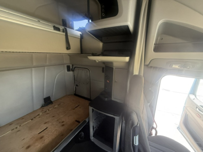 Peterbilt 579 sleeper cab interior showing bunk area and storage shelves.