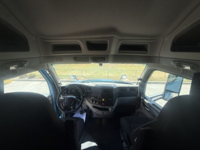 Peterbilt 579 truck interior cab view from back seat, dashboard with steering wheel and center console.