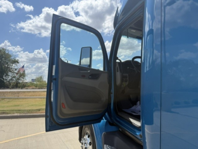 Peterbilt 579 truck cab interior with open door showing entry area and blue exterior.