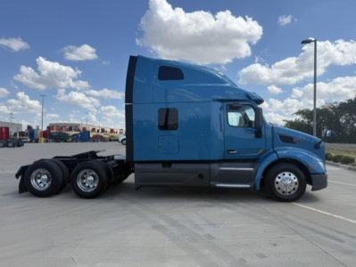 Peterbilt 579 conventional sleeper truck side profile in blue with triple rear axles and chrome wheels.