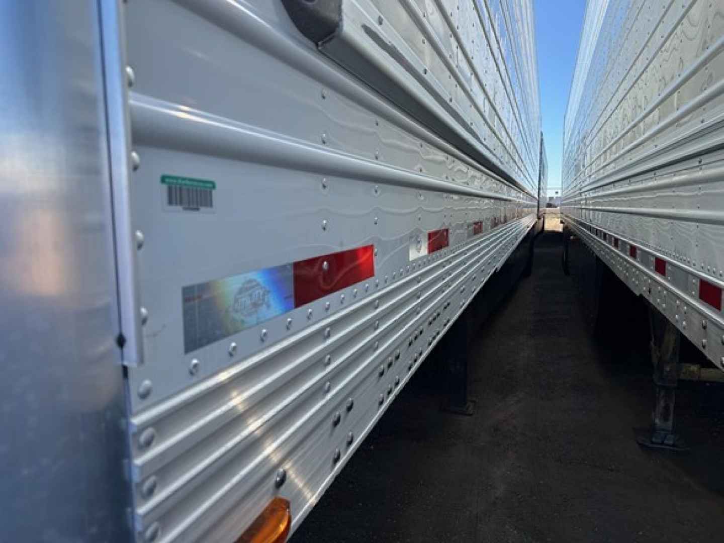 Reefer trailer side panels with reflective decals and clearance lights visible between two trailers.