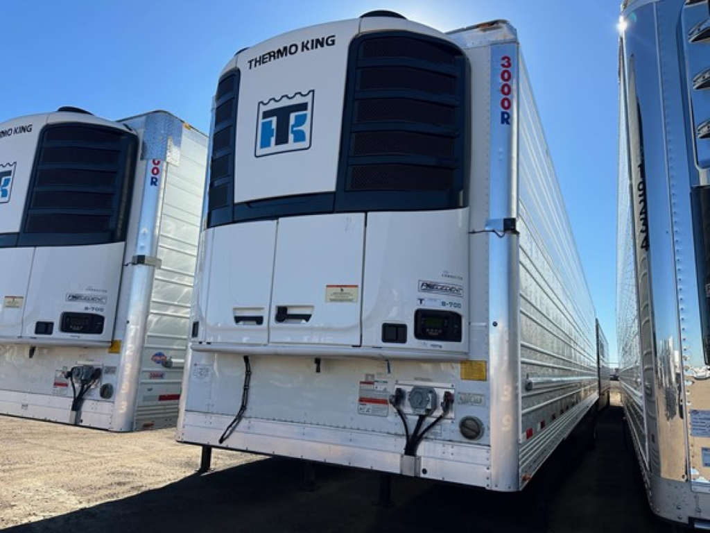 Reefer trailer showing Thermo King unit, white body, double doors, front view with branding and label panels visible.