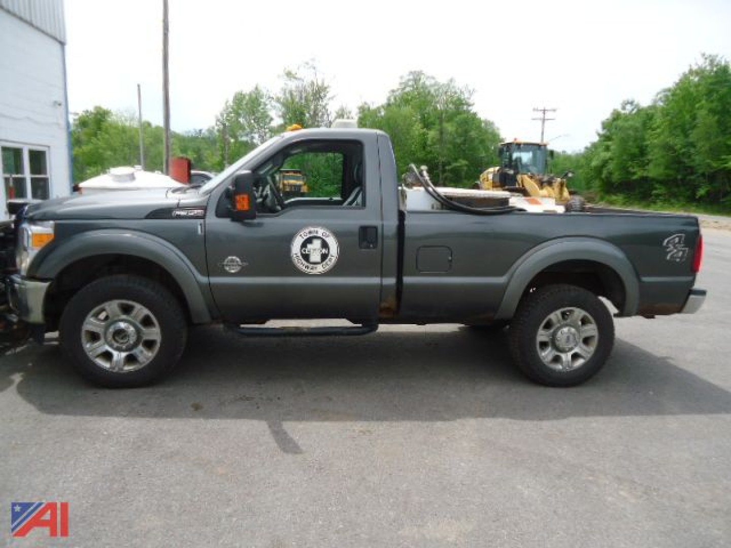Ford F-350 Super Duty pickup with plow in serviceable condition showing side profile and service logo on door.