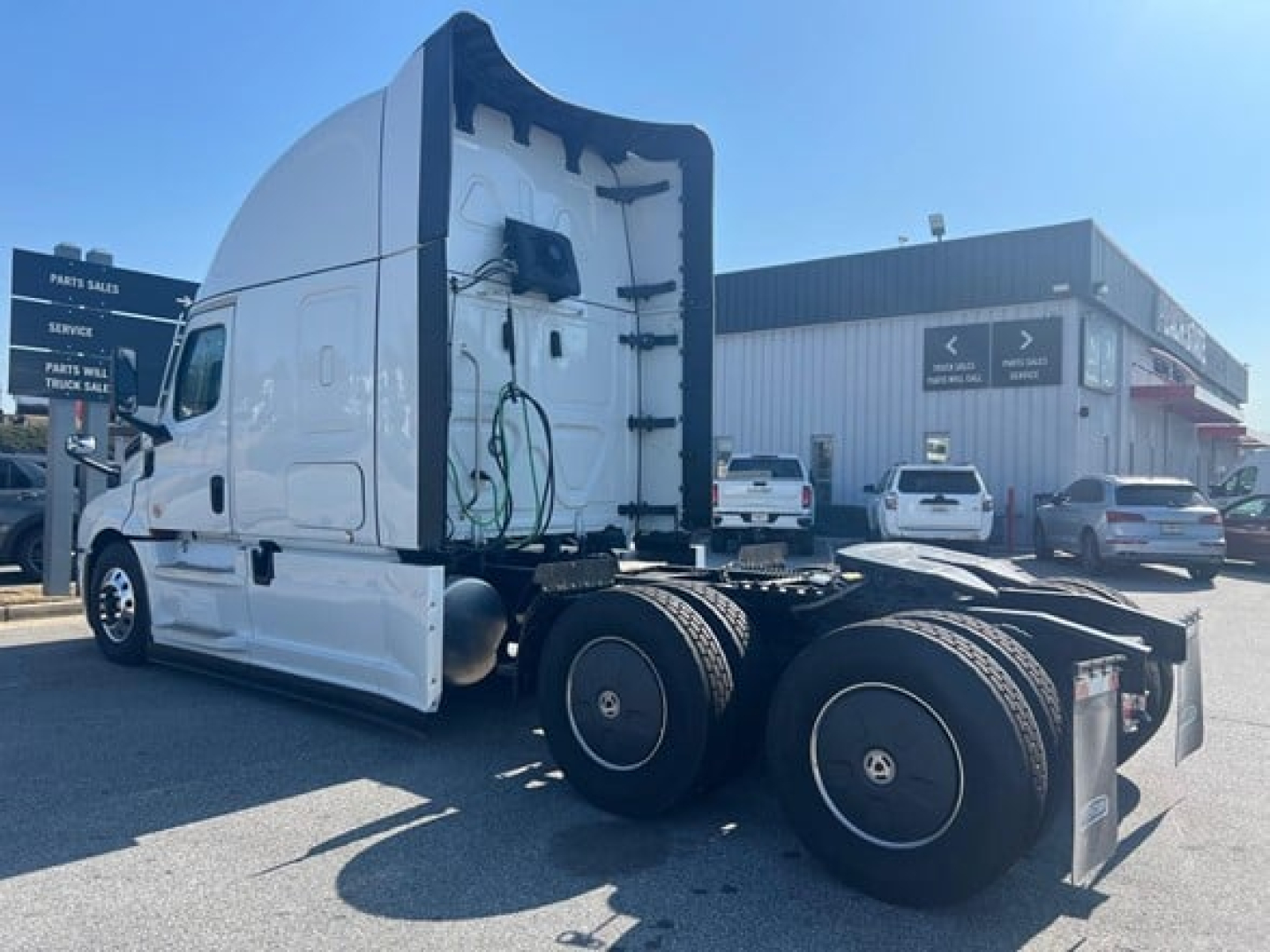 Truck rear view showing 6x4 axle configuration on a white 2026 Freightliner Cascadia 126 sleeper tractor.