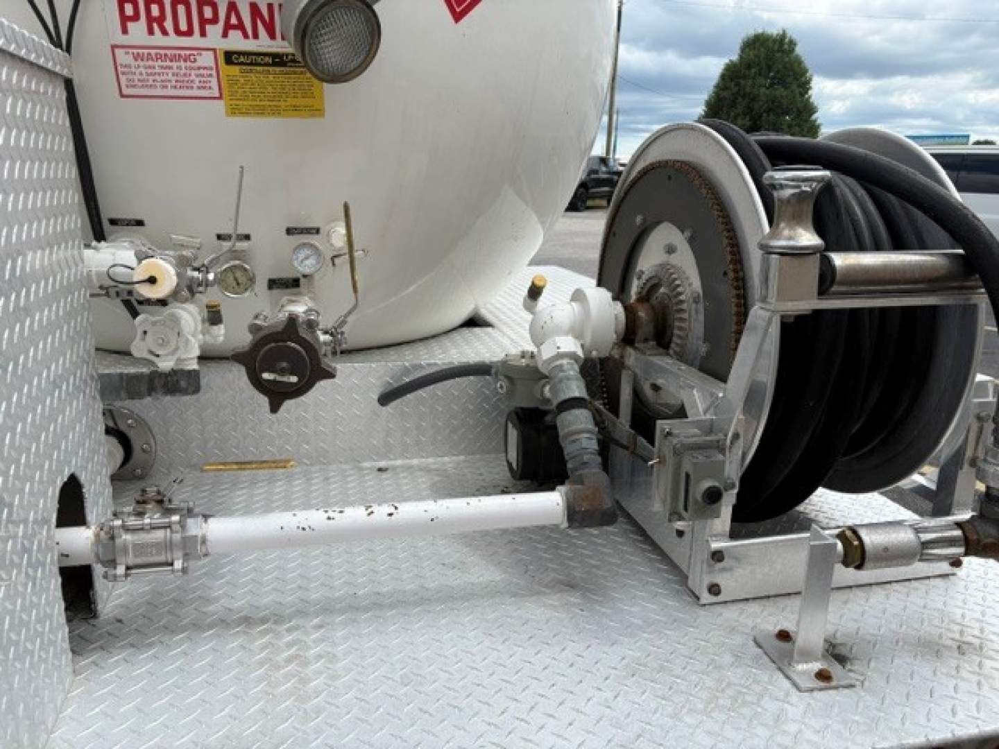 Hydraulic hose reel and tanked trailer components on a 2016 Ford F-750 chassis showing plumbing fittings and hose reel.