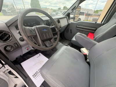 Ford F-750 cab interior showing steering wheel with Ford emblem, dashboard, and front seats.