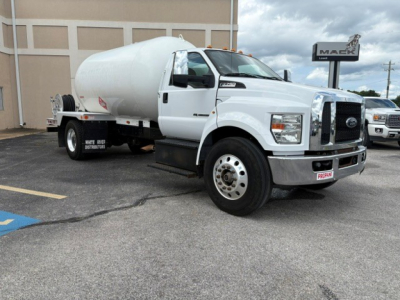 Ford F-750 medium-duty truck with white cab and large cylindrical tanker attached, side view showing front grille, wheels, and tank; VIN 1FDXF7DCXGDA03318 visible in listing context.