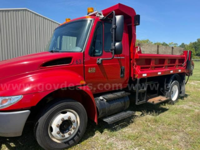 International 4300 truck with red plow bed showing side view and cab details.