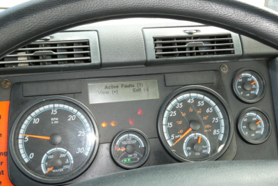 Dashboard of a 2017 Freightliner Cascadia 125 daycab showing gauges, warning lights, and a small digital panel with faults.