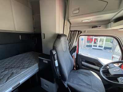 Kenworth T680 truck cab interior with sleeper berth and driver's seat in view.
