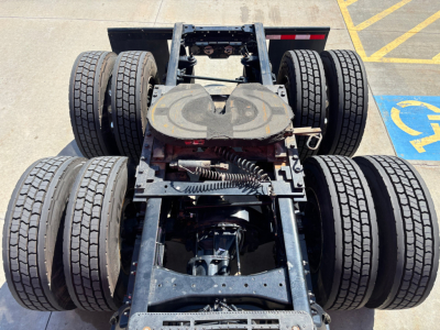 Kenworth T680 chassis view showing rear triple-axle configuration and dual rear wheels with fifth-wheel hitch.