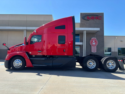Kenworth T680 sleeper cab truck in red, side view with stock number 0635691 visible and MHC dealership building background.