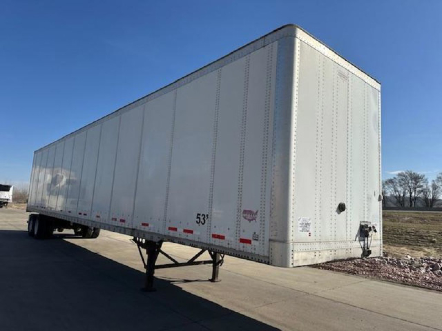Trailer body of a 2014 Wabash van trailer with 53' length, silver aluminum sides, rear doors, and landing gear visible, VIN 1JJV532D2EL812535.