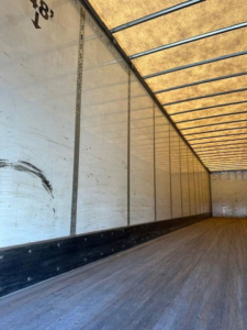 Trailer interior showing wooden floor and paneled walls of a Wabash van trailer.