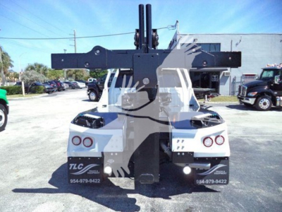 Ram pickup truck with a large rear winch assembly and mounting frame, showing various components and warning labels. visible text includes TLC and phone numbers on rear mudflaps.