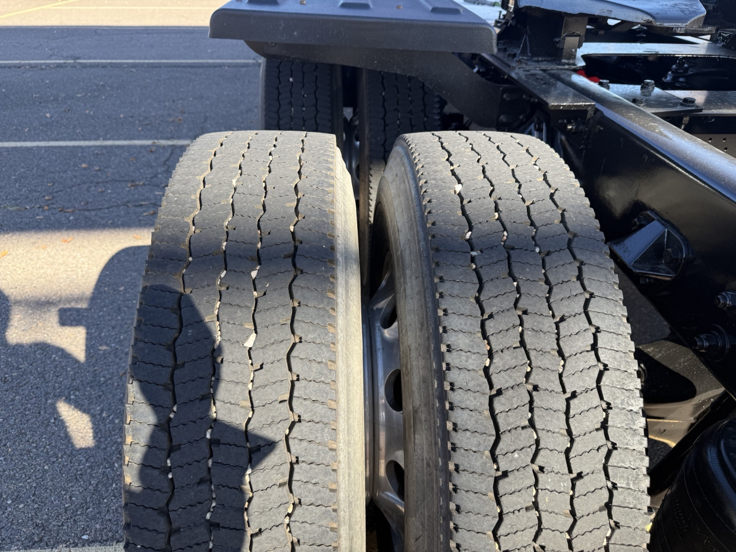 Dual rear wheels of a 2020 Kenworth T880 truck chassis with visible tires and suspension components.