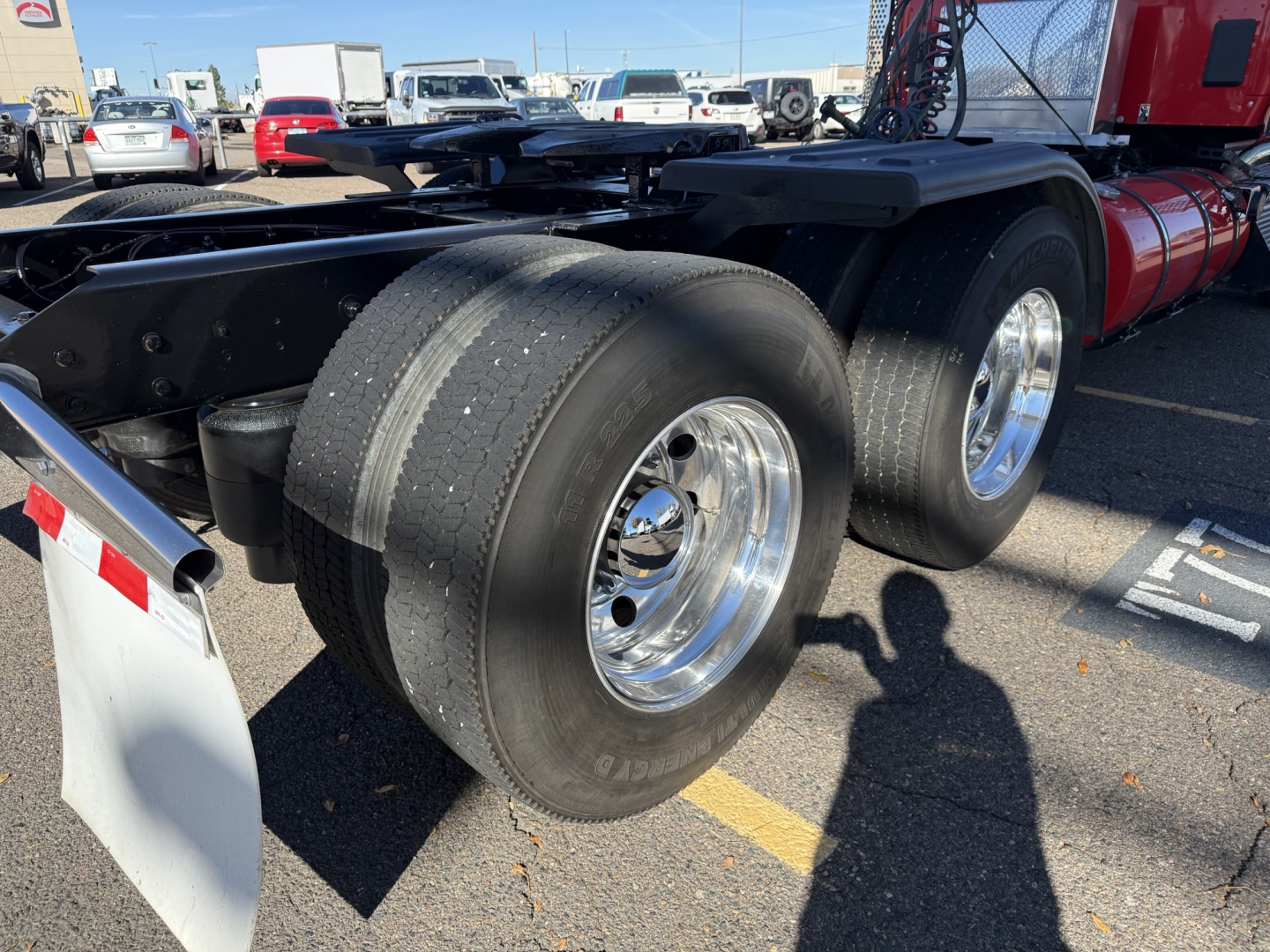 Kenworth T880 tractor rear wheels and chassis showing dual rear axles and chrome wheels.