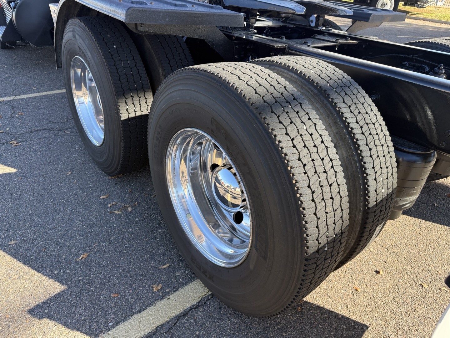 Kenworth T880 chassis showing dual rear axles with chrome wheels and dual tires.