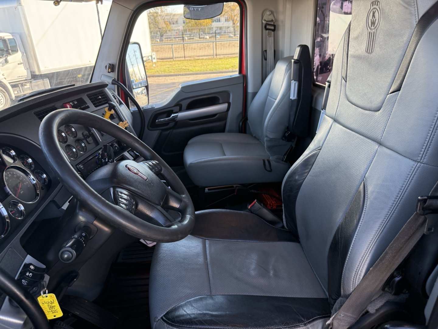 Kenworth T880 truck interior showing driver seat and passenger seat with dashboard and steering wheel.