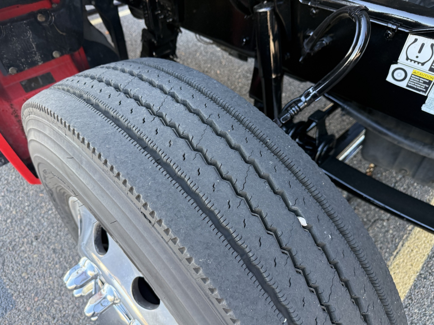 Kenworth T880 wheel/tire close-up showing front dual axle and tire tread with valve stem.
