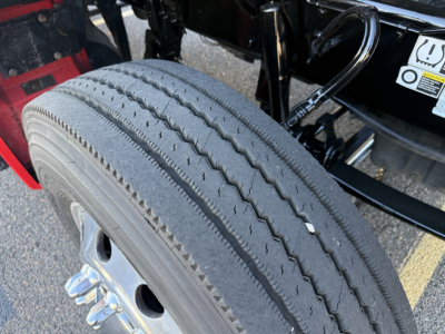 Kenworth T880 wheel/tire close-up showing front dual axle and tire tread with valve stem.