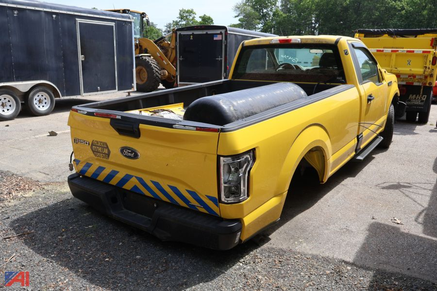 2016 Ford F-150 pickup truck rear quarter view in yellow with service bed and safety chevrons on tailgate and bumper.