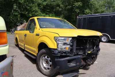 Yellow 2016 Ford F-150 pickup truck with front-end damage exposing internal components.