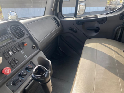 Cab interior of Freightliner M2-112 showing dashboard controls and front passenger seat.