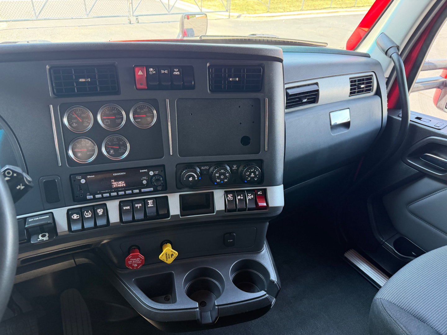 Kenworth T680 cabin dashboard showing gauges, switches, and controls from driver perspective