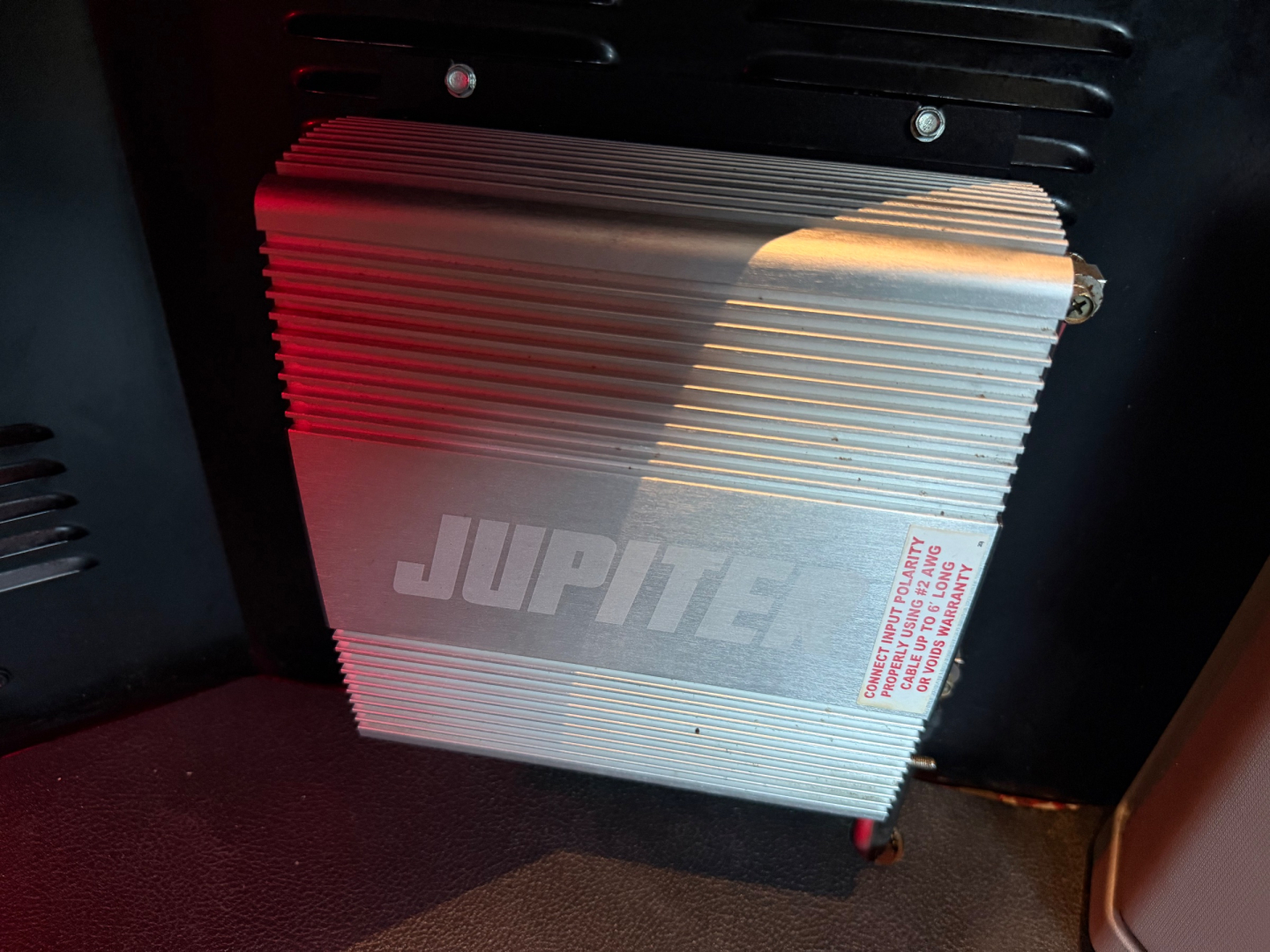 Astable aluminum JUPITER high-power module mounted inside truck cab area; ribbed heatsink with red light reflection.