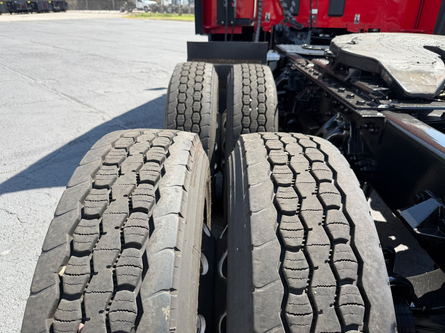 Kenworth T680 rear dual axle wheels and chassis showing tires and suspension in-service with tread pattern visible.