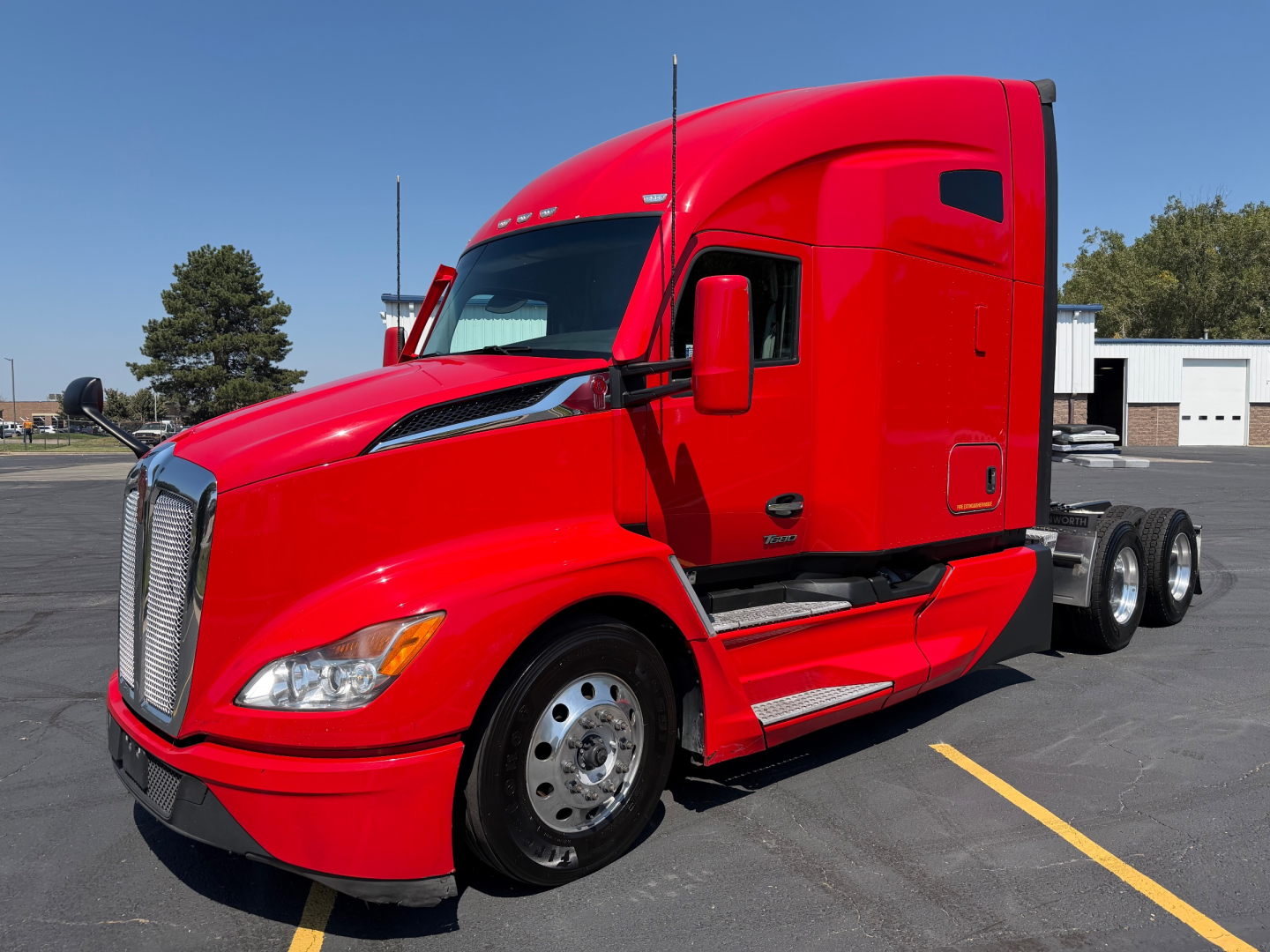 Kenworth T680 conventional sleeper truck in red, side view, cab with aerodynamic hood, large grille, dual rear axles.