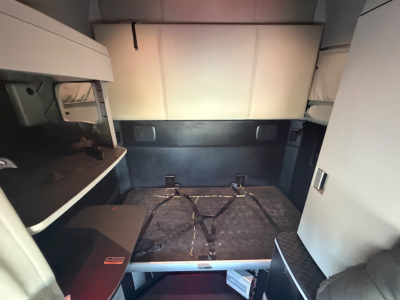 Kenworth T680 sleeper cab interior cargo area with rear seating/bed area and side storage compartments