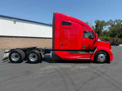 Kenworth T680 semi-truck side profile in red with sleeper cab, chassis and three rear axles visible.