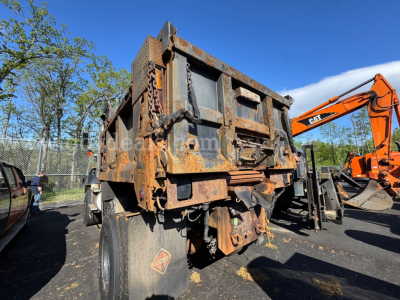 Dump truck dump body showing rusted metal with heavy frame and hydraulic components, 2004 International 5600i listing image.