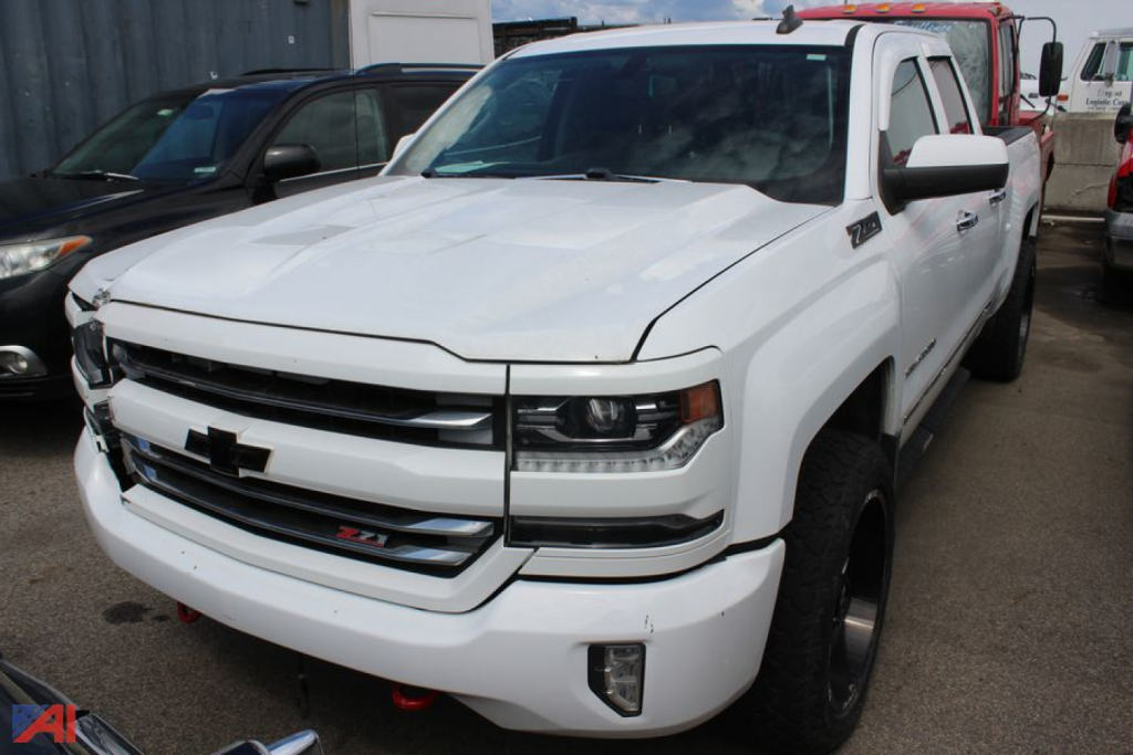 Chevrolet Silverado 1500 pickup (2018) front-left view; white exterior; 4x4 Z71 badge visible; partial dealership lot in background.