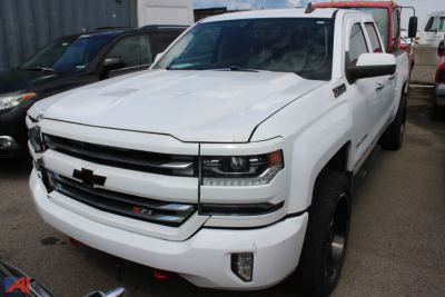 Chevrolet Silverado 1500 pickup (2018) front-left view; white exterior; 4x4 Z71 badge visible; partial dealership lot in background.