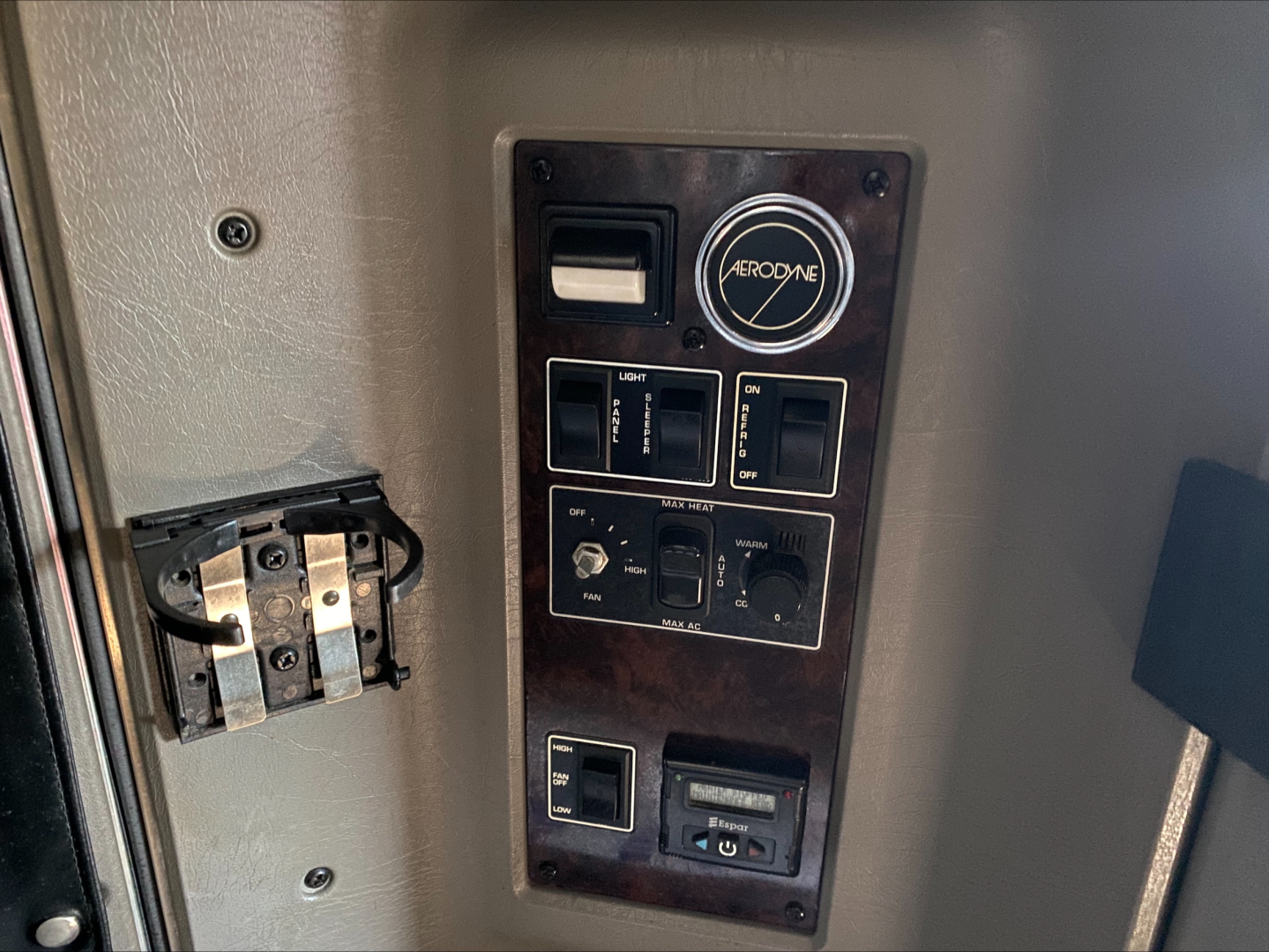 Kenworth W900L interior panel showing AeroOne controls and switches, with labels and indicators on a dark brown panel.