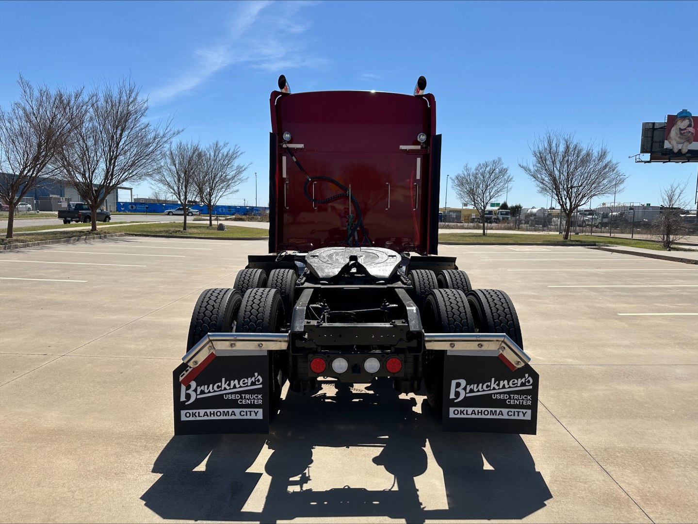 Kenworth W900L truck rear view showing dual rear axles and mud flaps with Bruckner’s Oklahoma City branding; VIN and stock number not visible.