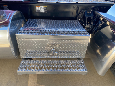 Kenworth W900L truck rear step with diamond plate toolbox and steps, showing under-truck storage box and side fuel tank area.