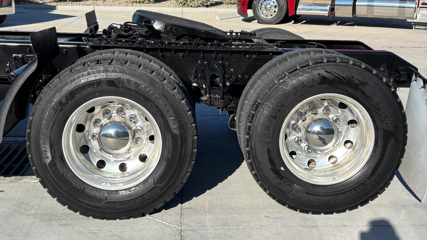 Twin rear truck wheels on a Kenworth T880 chassis showing dual tires and chrome wheels.
