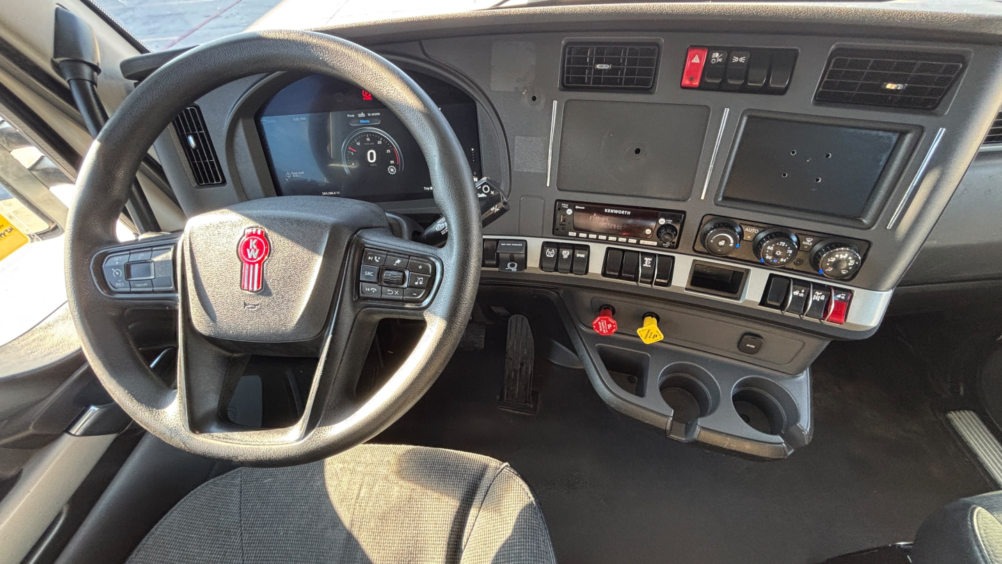 Kenworth T880 interior dashboard and steering wheel showing instrument cluster, controls, and center console.