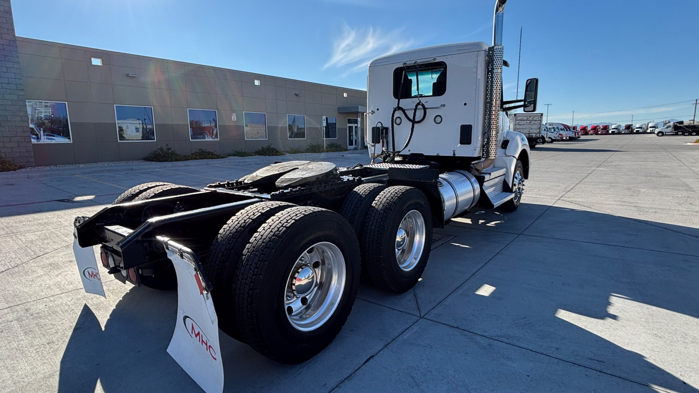 Kenworth T880 tractor–rear view showing fifth wheel and dual rear axles with white cab.