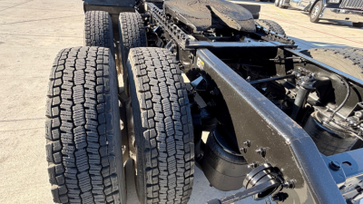 Kenworth T880 chassis showing dual rear axles and tire tread details.