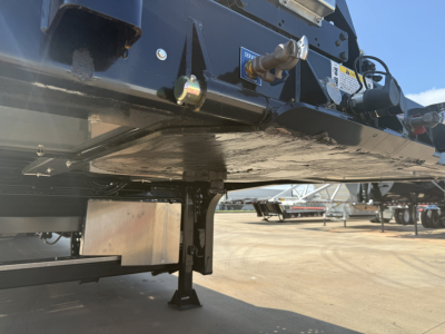 Traveling axle trailer undercarriage showing landing gear and frame with hydraulic components and support jack.