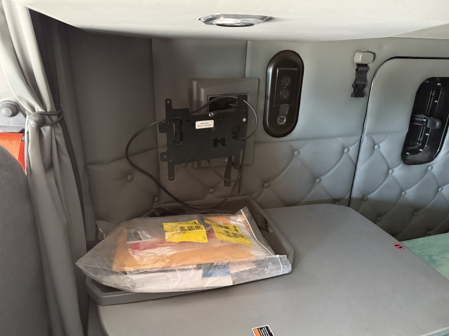 Kenworth T680 sleeper cab interior side showing electrical panel and packaged item